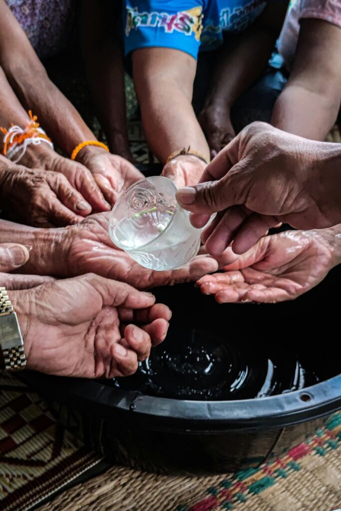 Elder hands getting jasmine scented water poured on them