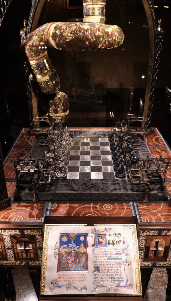 Jewelled robotic arm, chessboard, and Voynich-style manuscript for Joseph Arzoumanov's Chessboard of Dreams, L’Échiquier des Songes.