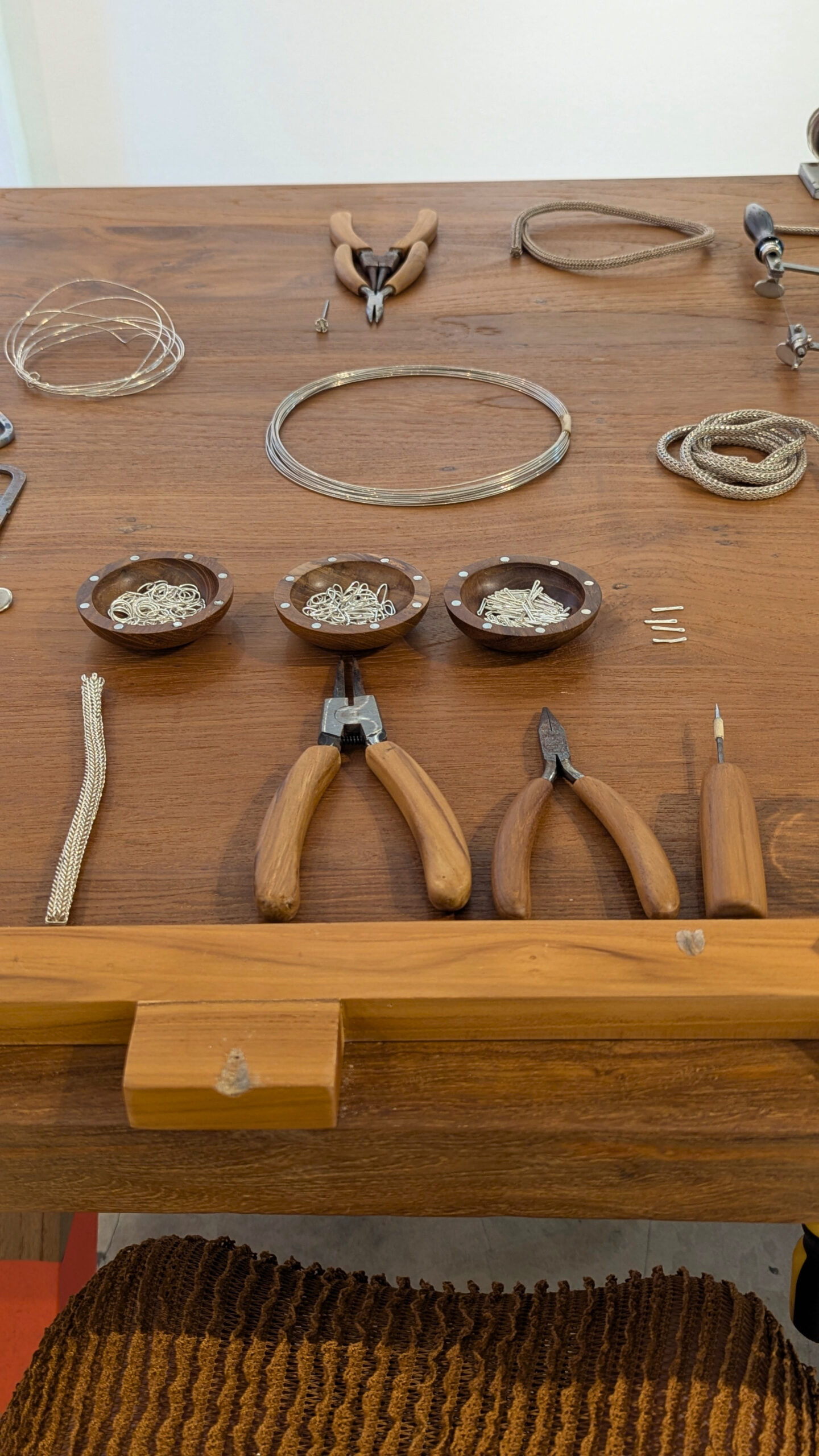 John Hardy Icon Chain Workshop setup. Silver wire is transformed manually with pliers and flame into individual links that then get weaved into the brand's signature chain bracelet.