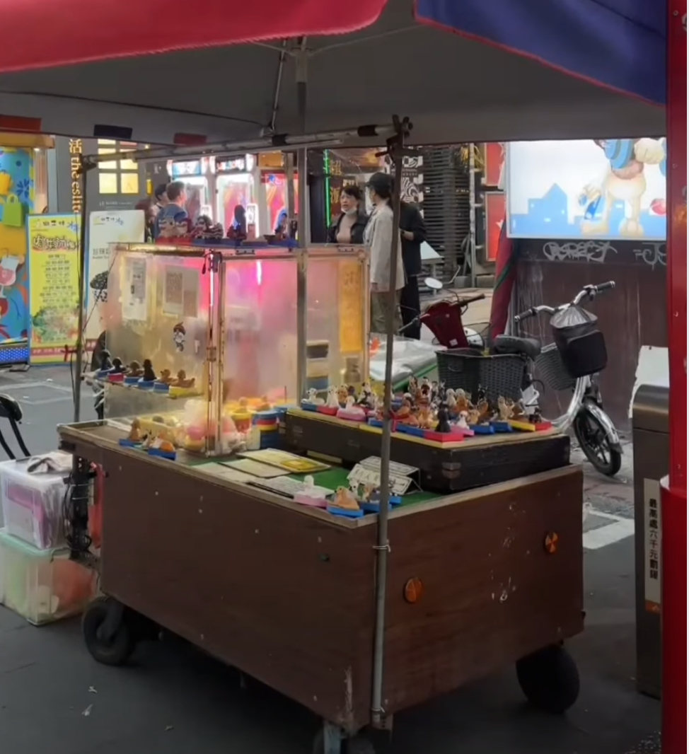 An artisan’s stall in Ximending, Taipei, where the ancient craft of Nie Mian Ren (dough sculpting) is reimagined. He distills over 30 years of mastery into lifelike miniatures of a customer’s most cherished companion, a clay pet