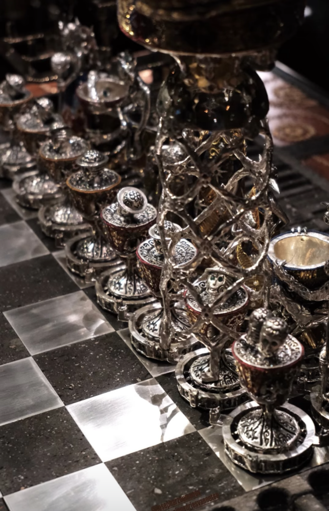 SBlackened silver cage picking up one of grandpa's hand-crafted pawns in Joseph Arzoumanov's Chessboard of Dreams - L'Échiquier des Songes.