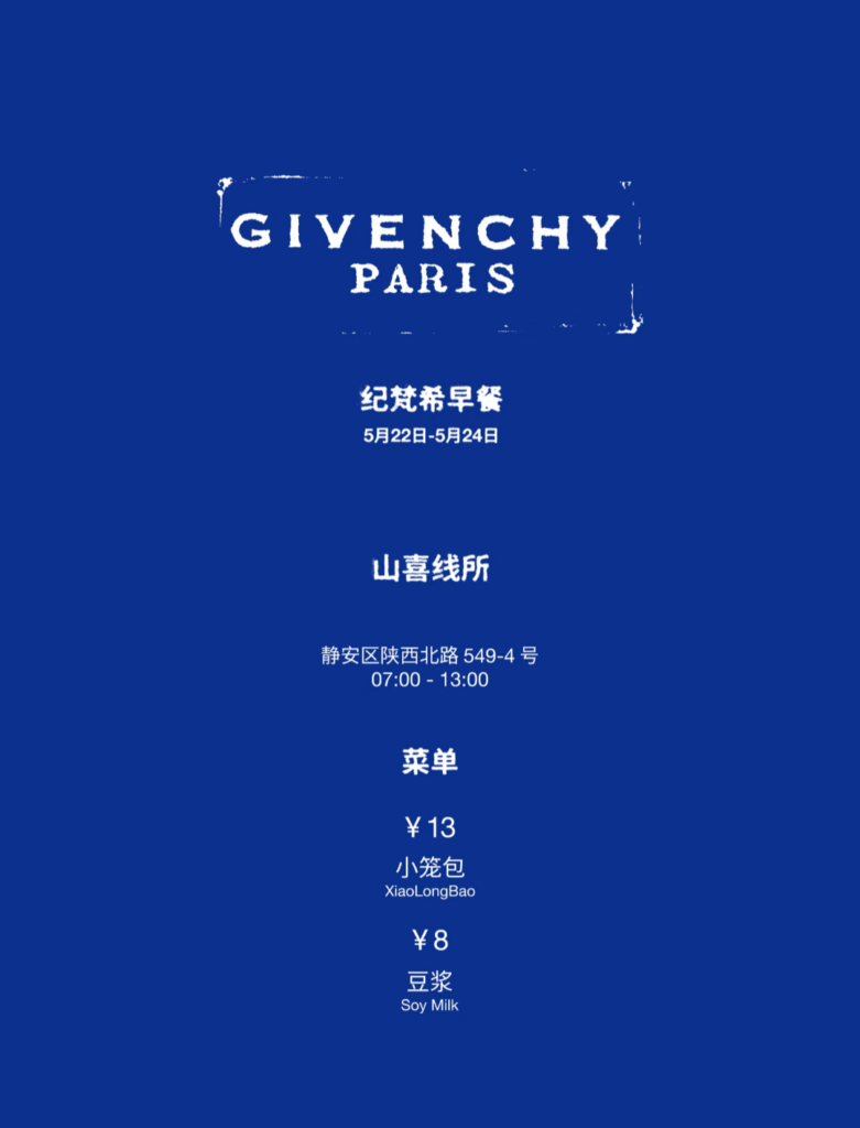 山喜线所 (Shanxi Noodle Shop)'s blue menu placard for Givenchy's 2026 Shanghai pop-up: 纪梵希早餐 (Givenchy Breakfast) serving 小笼包 (XiaoLongBao / Soup Dumplings) and 豆浆 (Soy Milk)