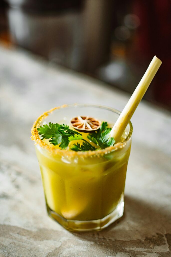 Glass of jamu with cilantro, lemongrass, and turmeric